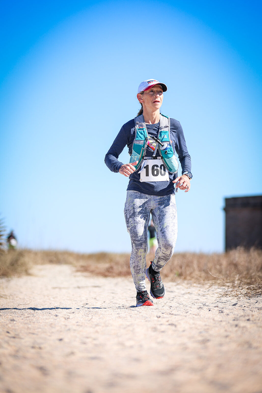 Woman in star leggings smiling on sandy trail