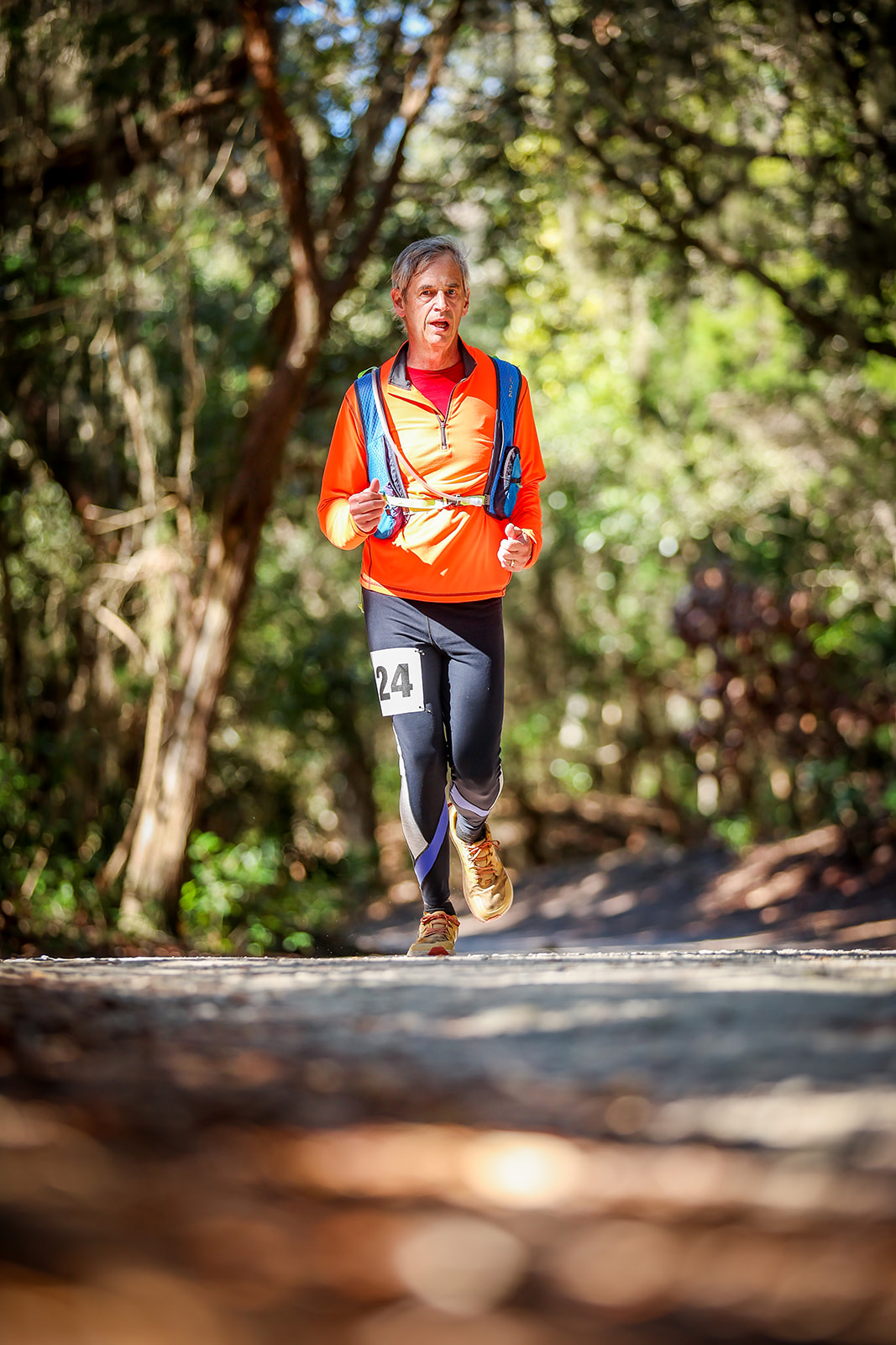 Runner in bright orange under vivid green canopy